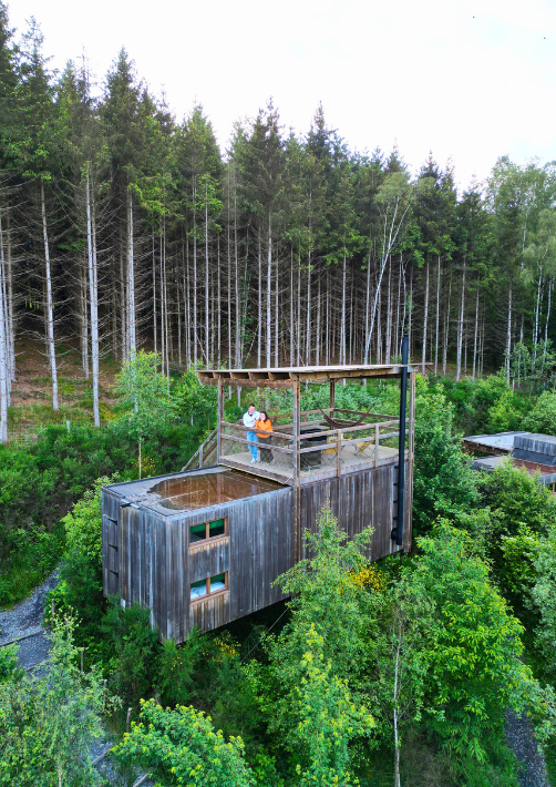 A couple on the rooftop terrace of a cabin in the woods in the Ardennes