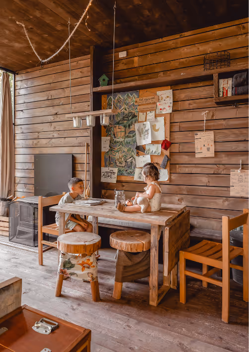 Two young siblings in a cabin in the woods in Alsace, enjoying their time during a holiday with kids