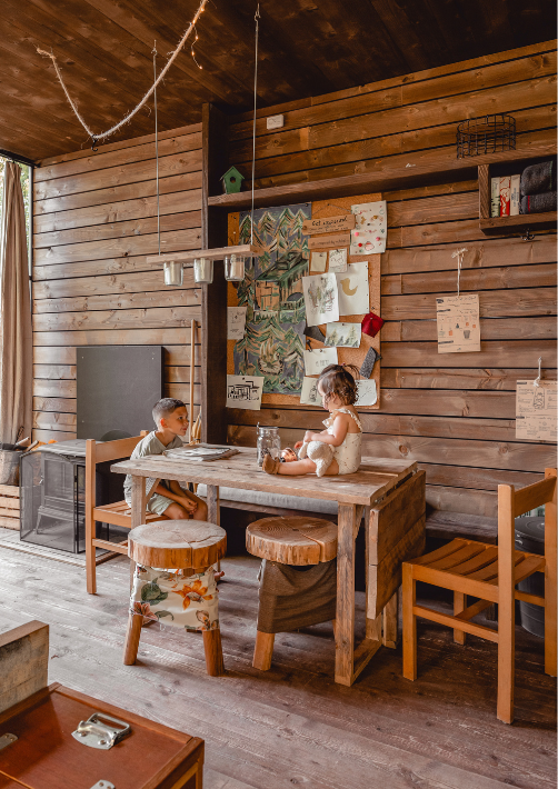 Zwei junge Geschwister in einer cabin im Wald im Alsace, die ihre Zeit während eines Urlaubs mit Kindern genießen