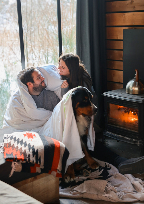 A couple with their dog in a cabin in the woods in Alsace, after the husband offered a Nutchel stay to his wife as a gift for Valentine's Day