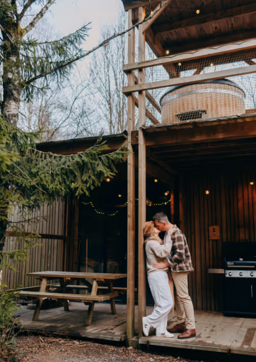A couple kissing on the terrace of a cabin in the woods in France on Valentine's Day