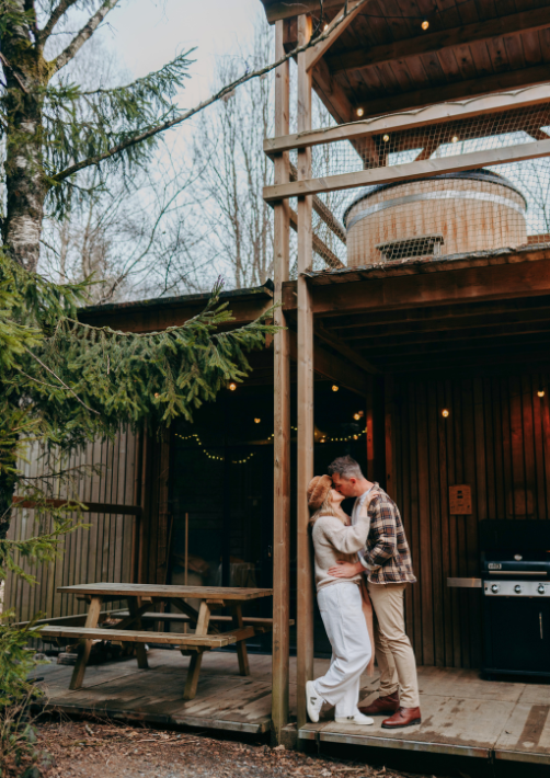 A couple kissing on the terrace of a cabin in the woods in France on Valentine's Day