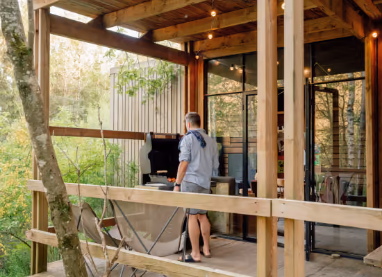 The terrace of a Soul cabin, a tiny house near Paris, with a Nutchel guest cooking a barbecue on it