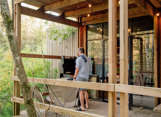 The terrace of a Soul cabin, a tiny house near Paris, with a Nutchel guest cooking a barbecue on it