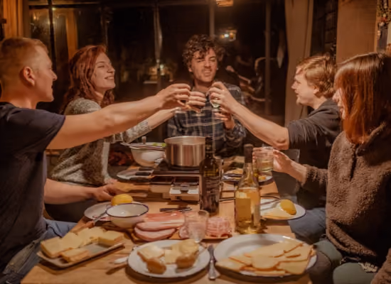 Des amis trinquant dans une cabane lors d'un séjour en week-end