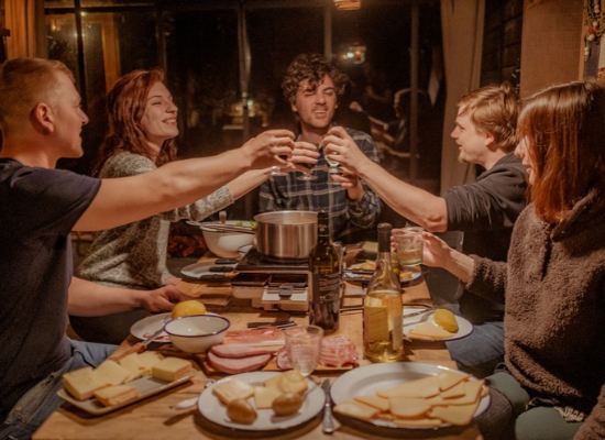 Friends raising a toast inside a cabin during a weekend getaway