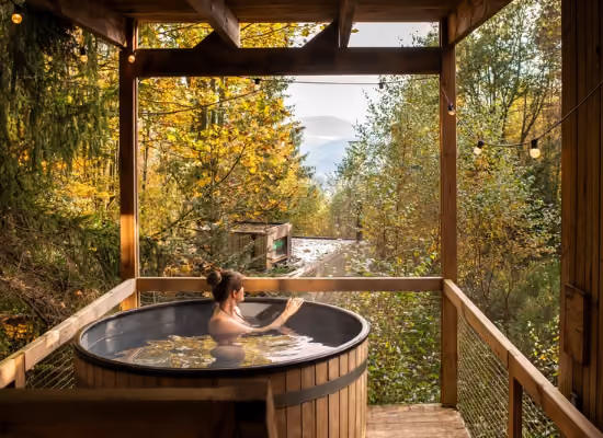 Een vrouw die het uitzicht bewondert vanaf zijn cabin met hot tub