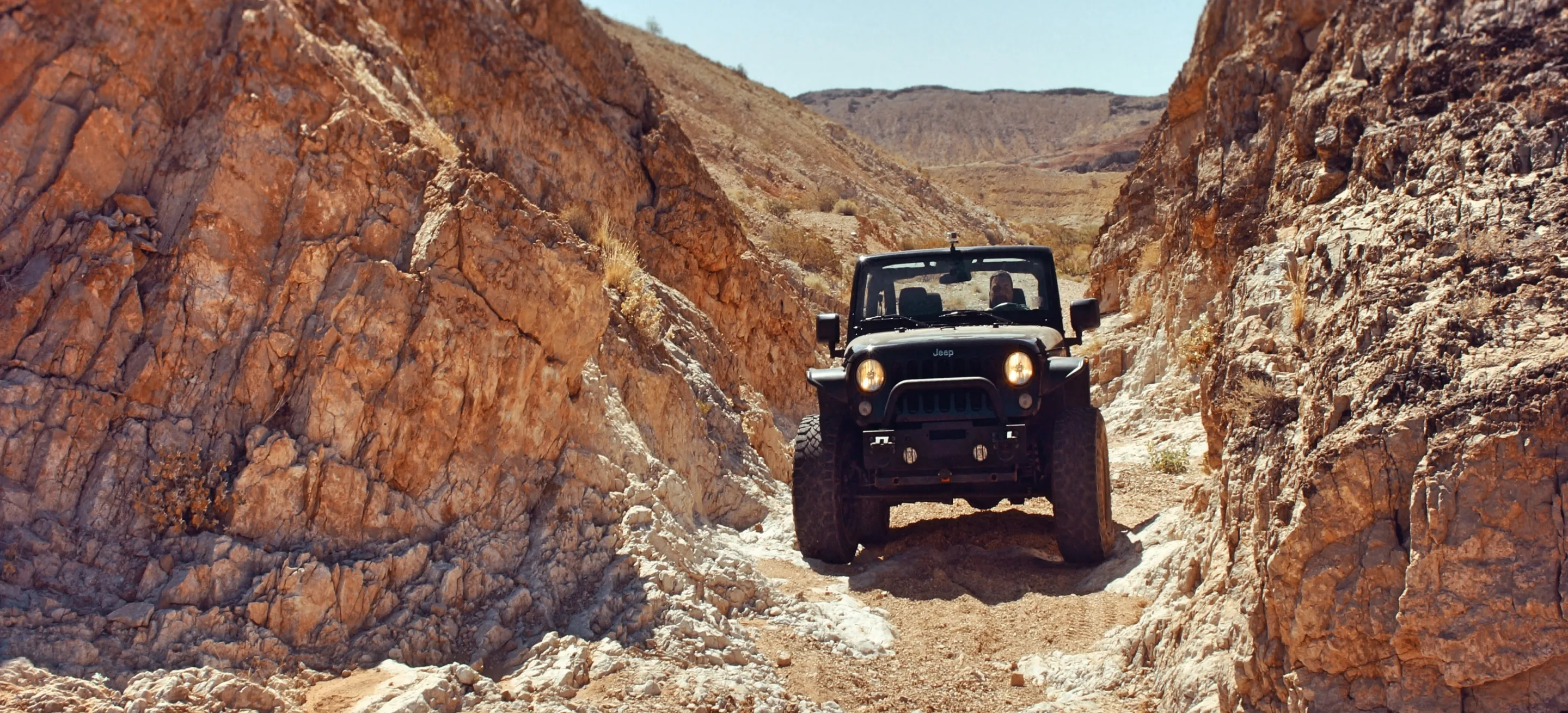 a jeep between two rocks