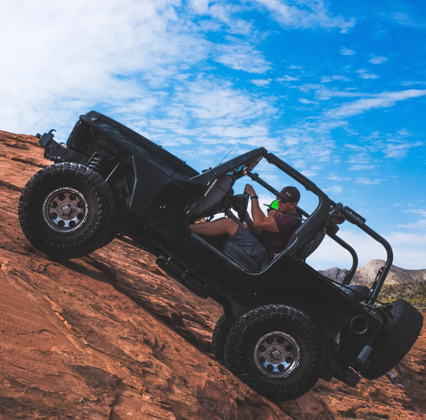 a jeep climbing to the rock with tourists
