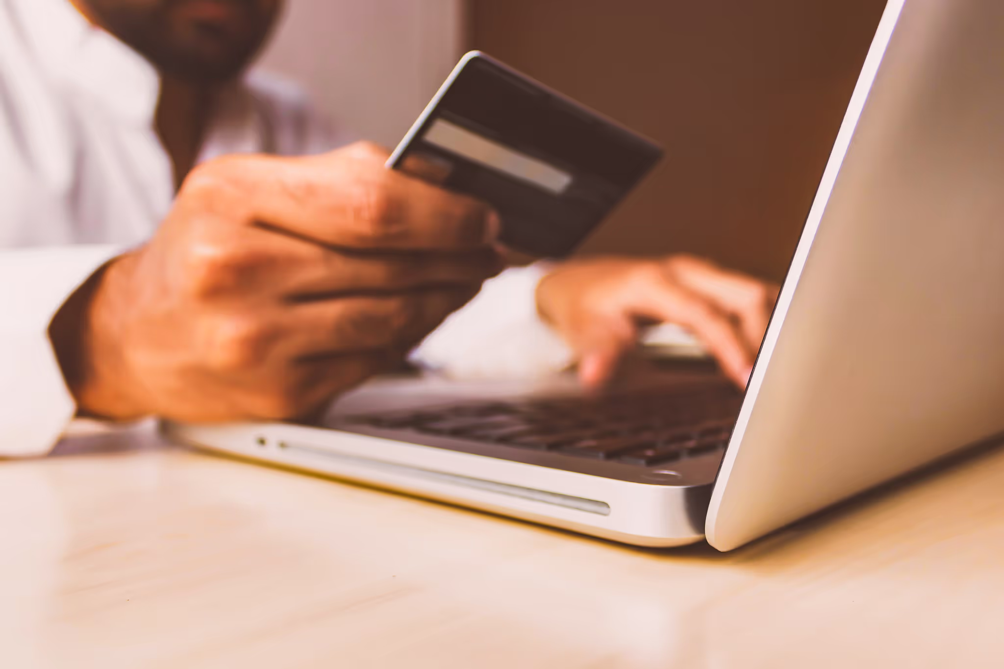 person putting their credit card information into their computer