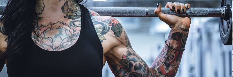 Women with tattoos lifting weights