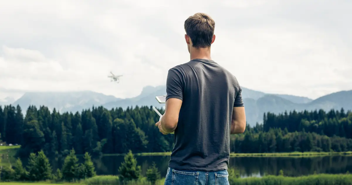 A drone pilot operating a drone in a mountainous area to provide drone photography services.