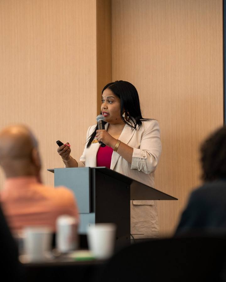 Shana Sanders leading an AI session at a podium
