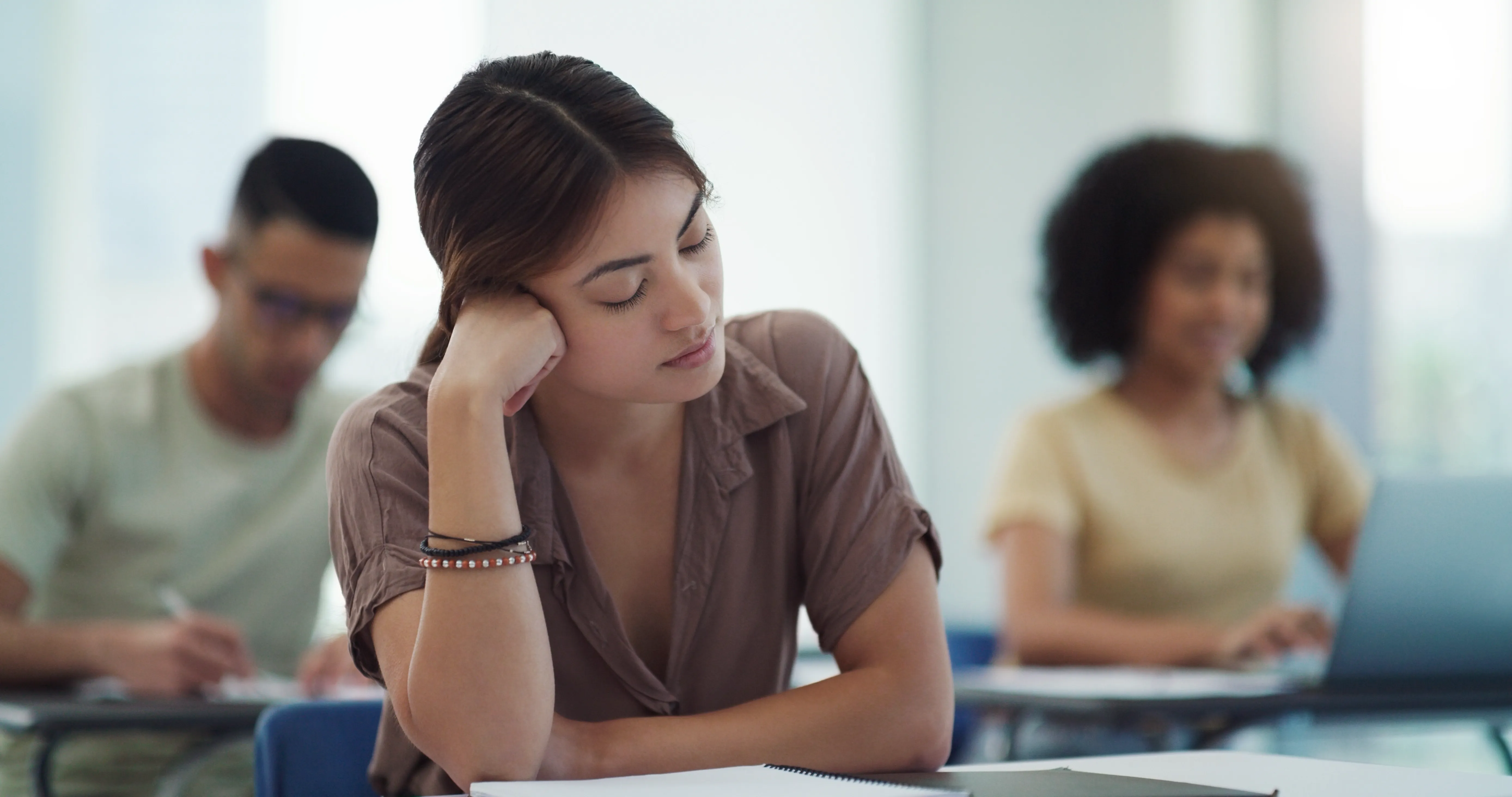 An image of a woman sitting in a classroom