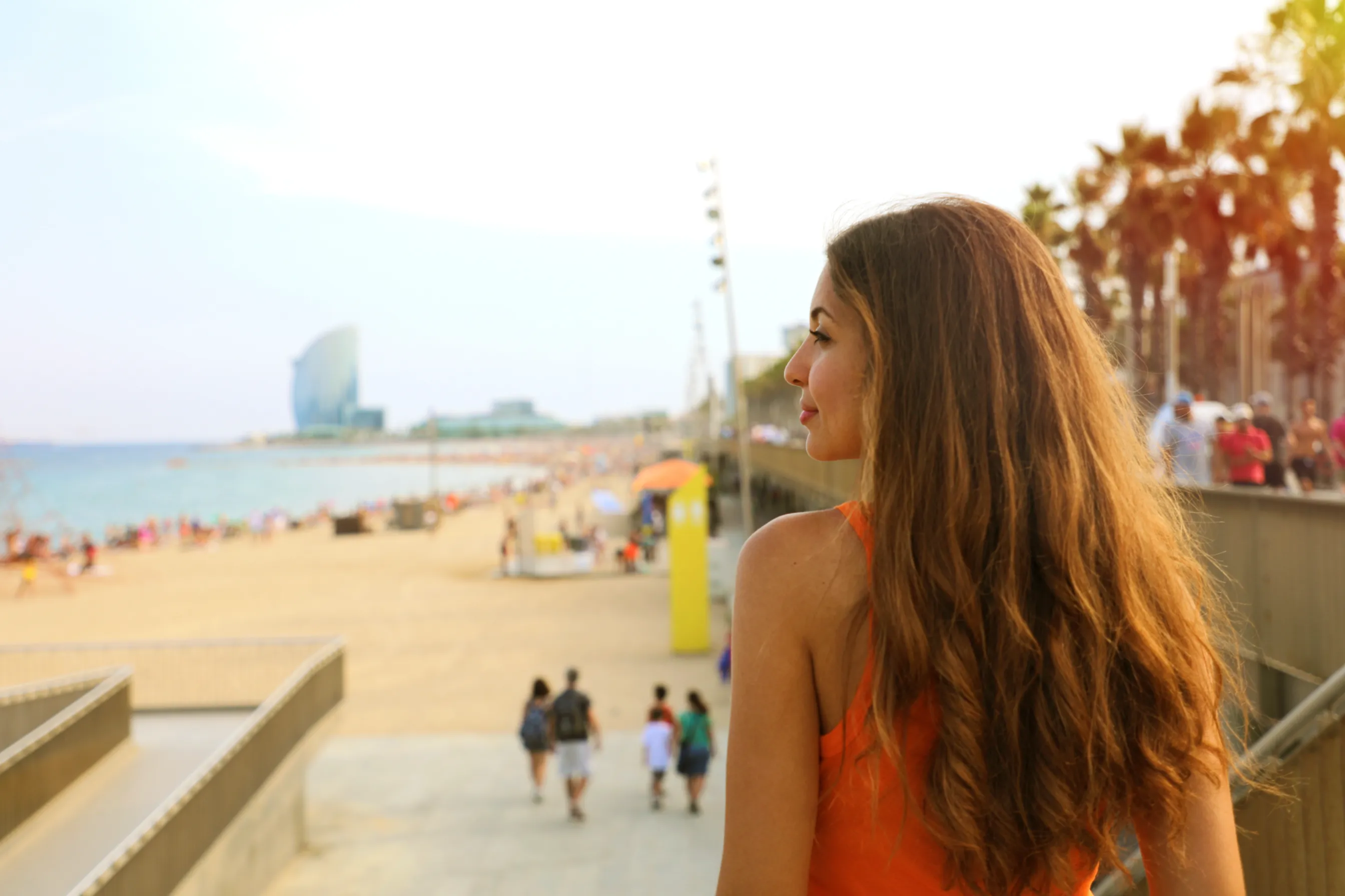 A woman looking out at a Florida beach during the golden hour.