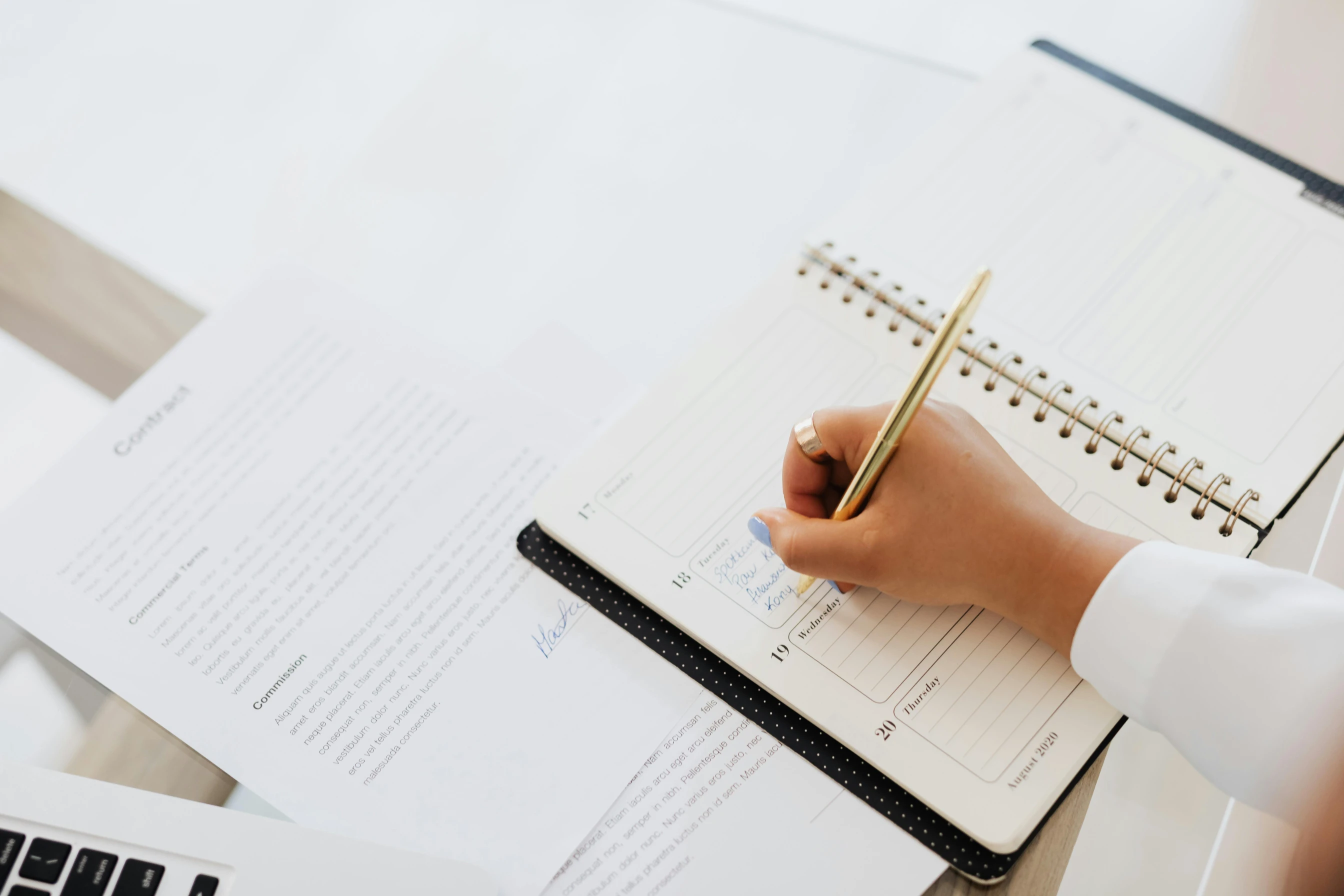 Someone writing in a planner to stay on top of their tasks.