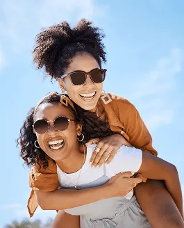 two woman with sunglasses riding piggy back