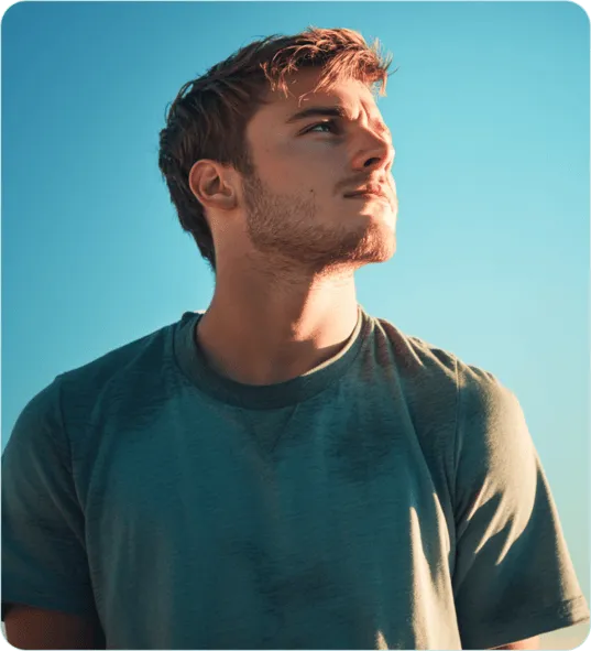 man with a blue shirt looking towards the sun