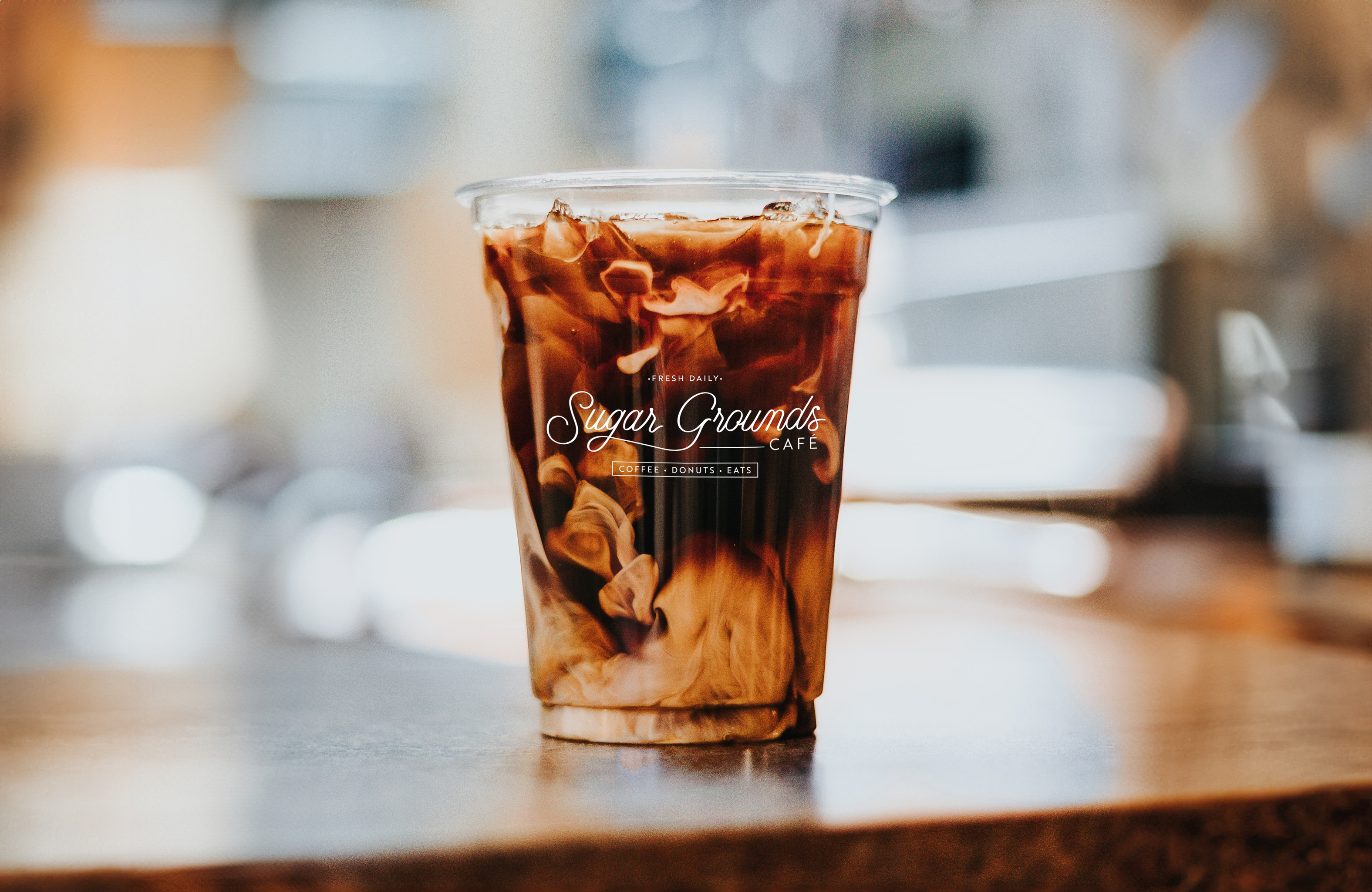 iced coffee cup with sugar grounds logo