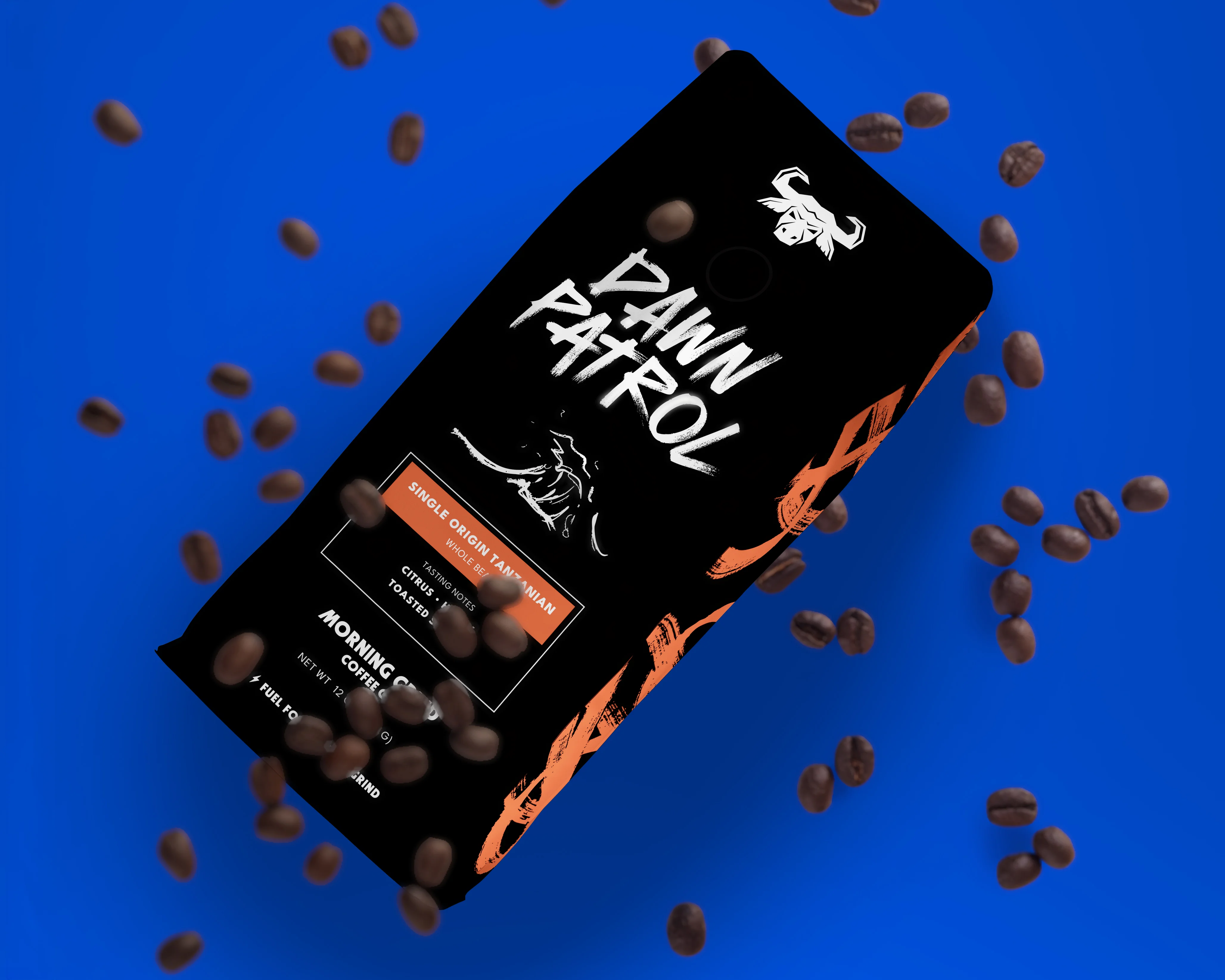 A black coffee bag with the words Dawn Patrol written in an energetic brush stroke font on the front. Also on the front of the bag is a sketchy looking hand drawn illustration of a wave. The sides of the bag are black with red orange scribbles. The bag is against a royal blue background with scattered coffee beans falling all around it.