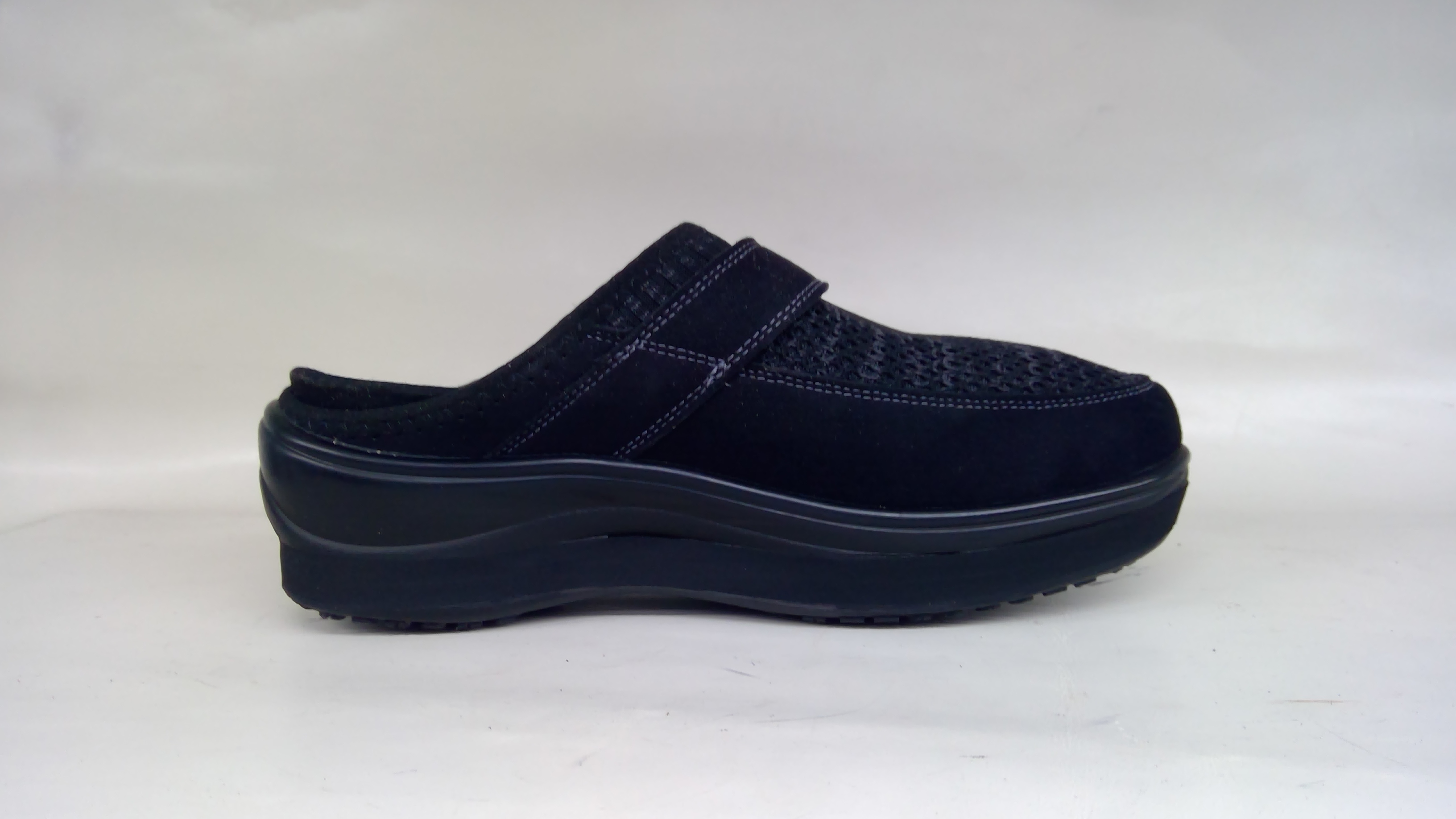 Black orthopedic shoe with elevated platform sole and mesh upper, completed shoe lift modification by Mont Clare Repair Center