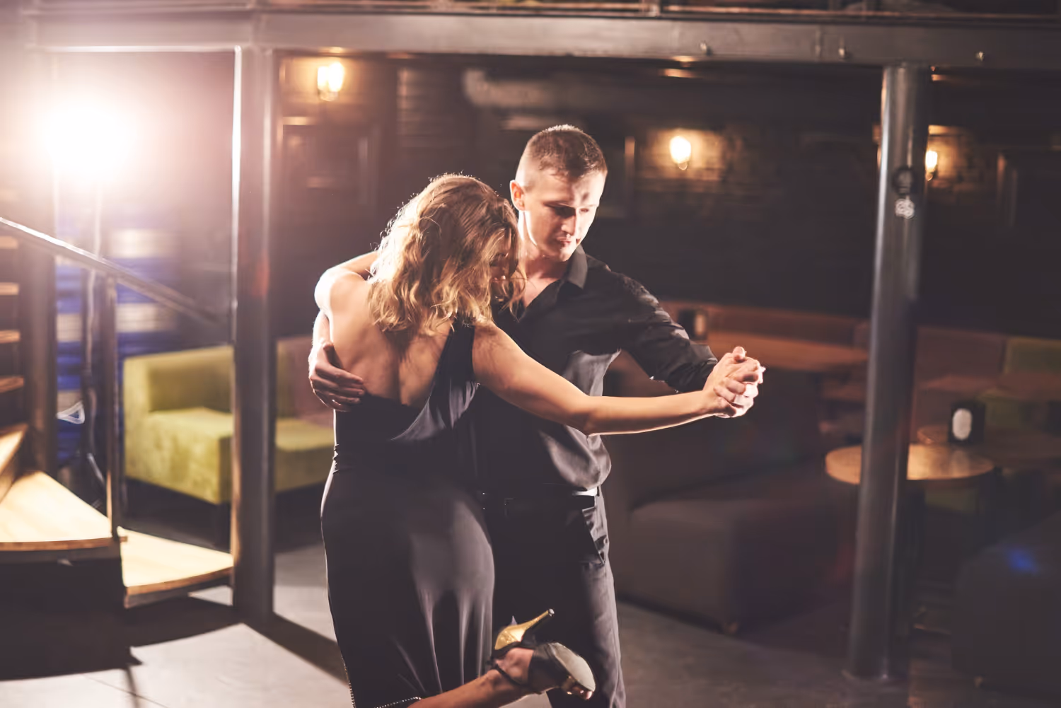 Free photo skillful dancers performing in dark room under light.