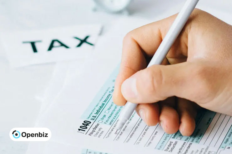 Primer plano de una mano firmando un formulario de impuestos de EE.UU. 1040 para presentar al IRS
