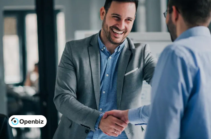Two business professionals shaking hands after reviewing legal documents for an LLC Operating Agreement