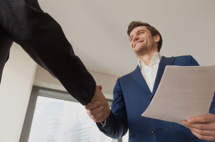 Two entrepreneurs shaking hands after closing a deal to expand a scalable business in the U.S. market.
