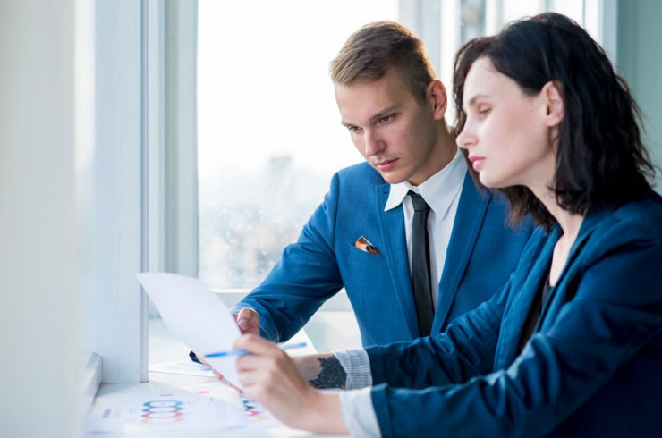 Two professionals reviewing paperwork for a business license in the United States