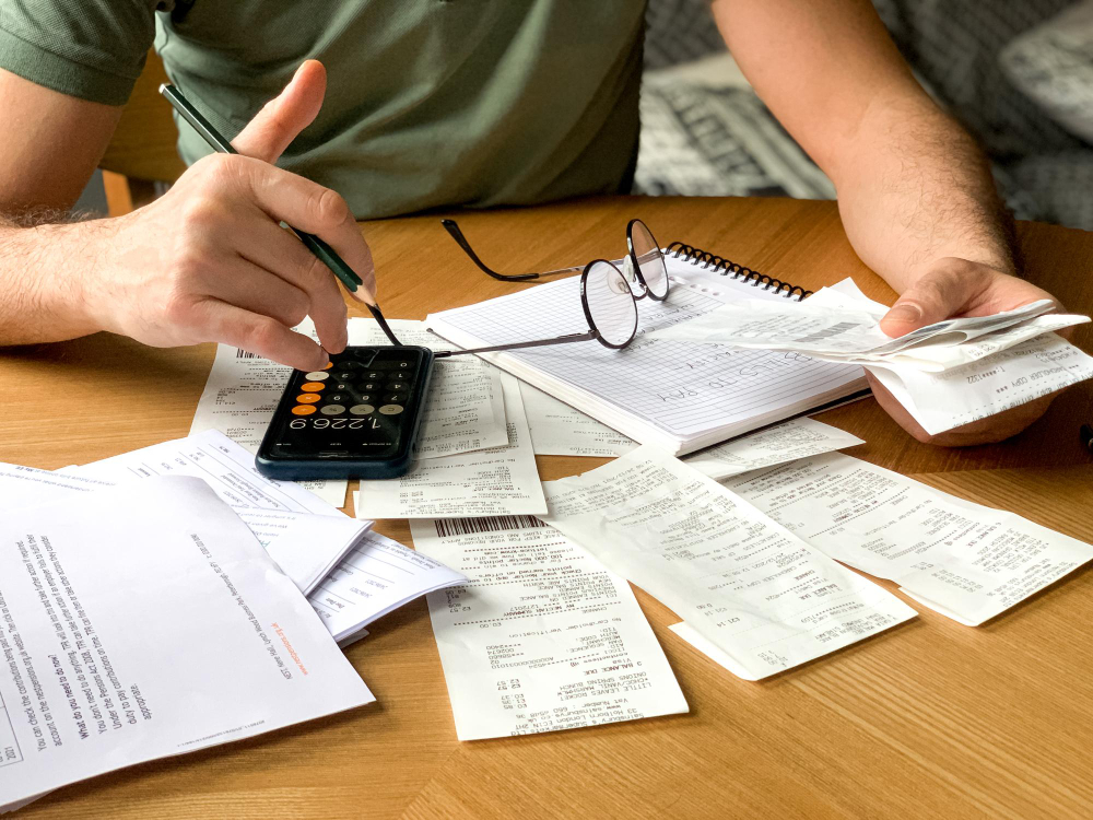Person using a calculator and reviewing financial documents related to tax-exempt income.