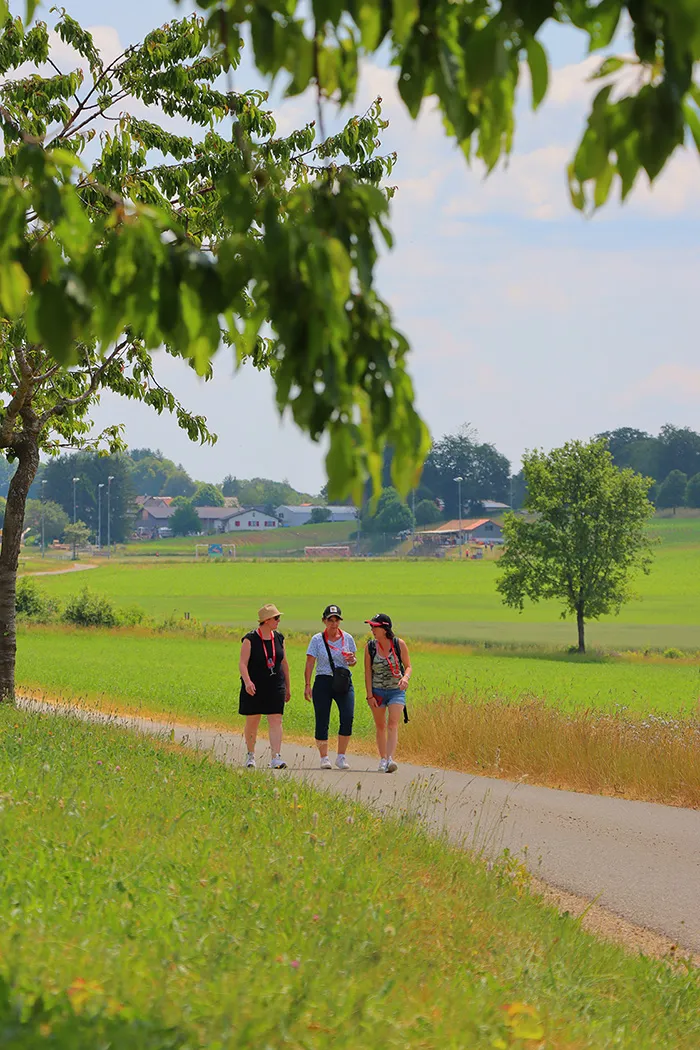 Des personnes marchant autour du sentier panoramique de Pleigne
