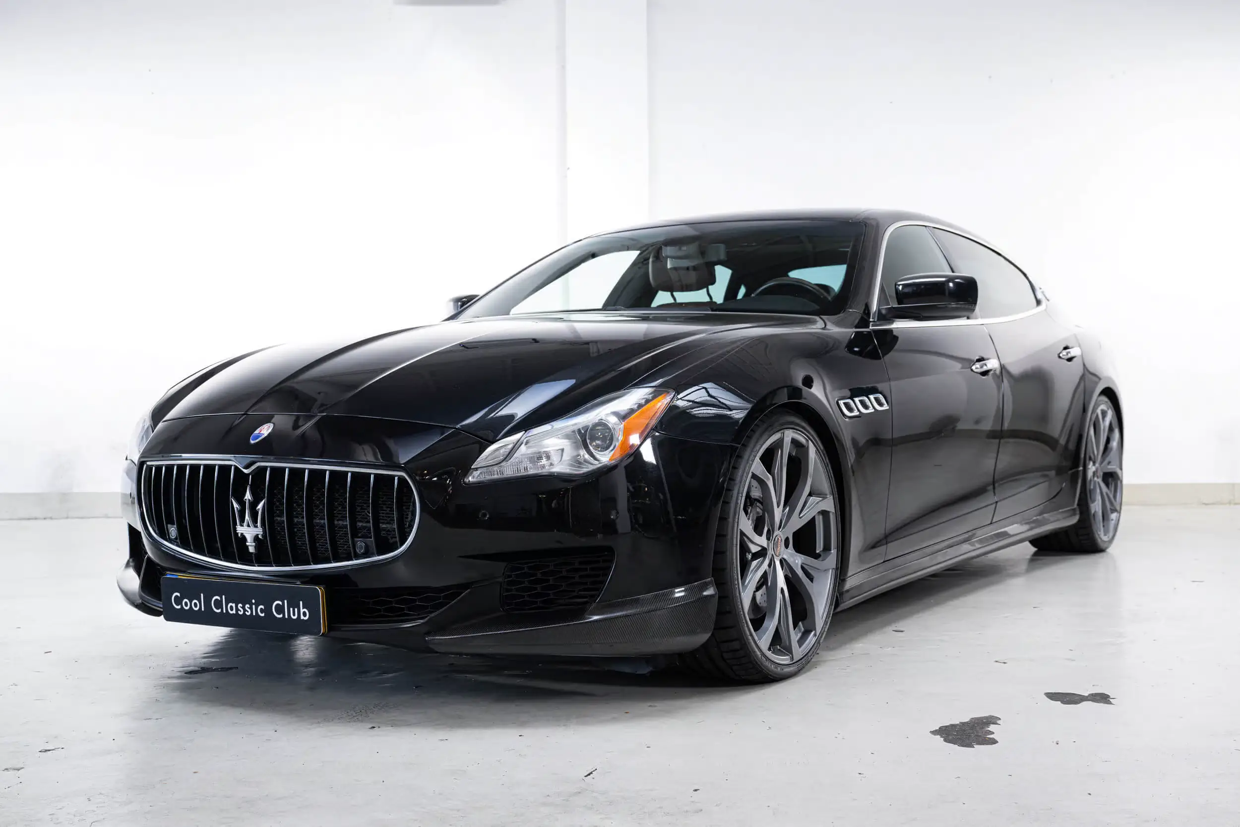 Front oblique view of the 2013 Nero Carbonio metallic Maserati Quattroporte GTS Novitec