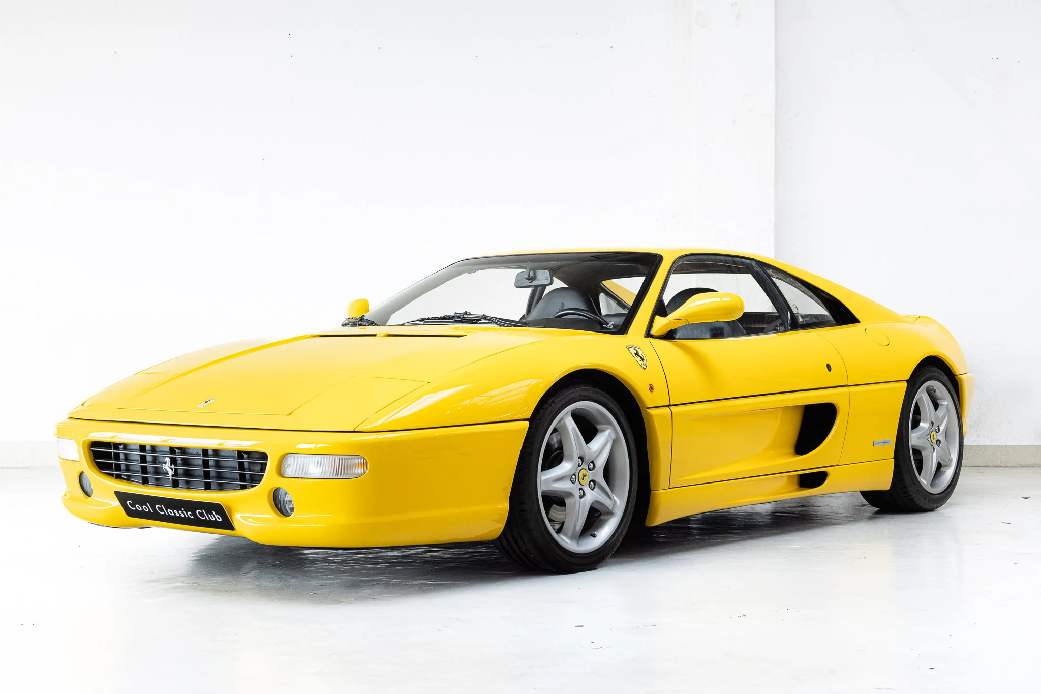 Schuin zicht op een Ferrari F355 GTB uit 1995 in Giallo Modena.