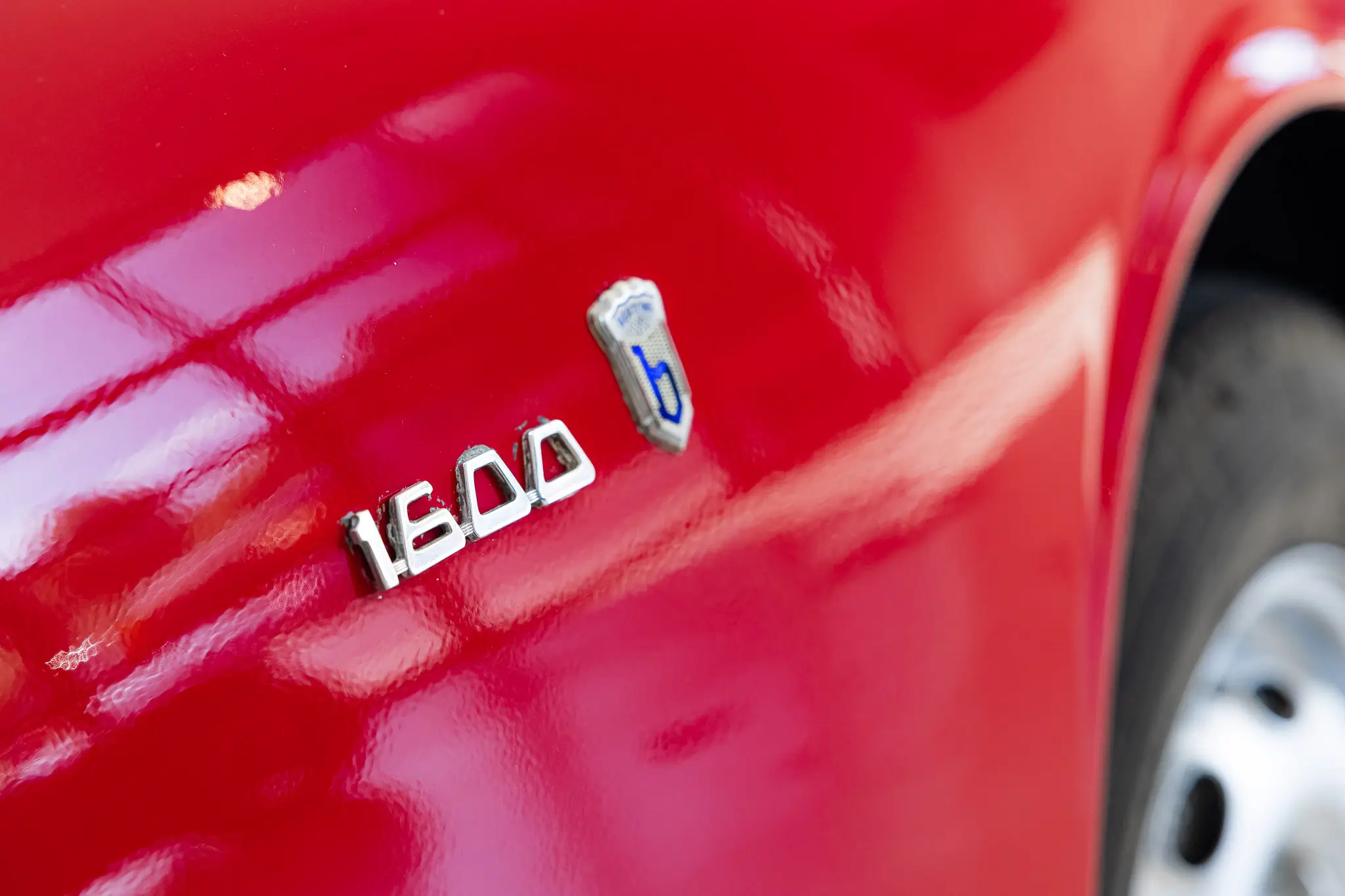 Alfa Romeo Giulia 1600 Sprint 1963 in Rosso Alfa, showcasing a close-up of the 1600 badge.