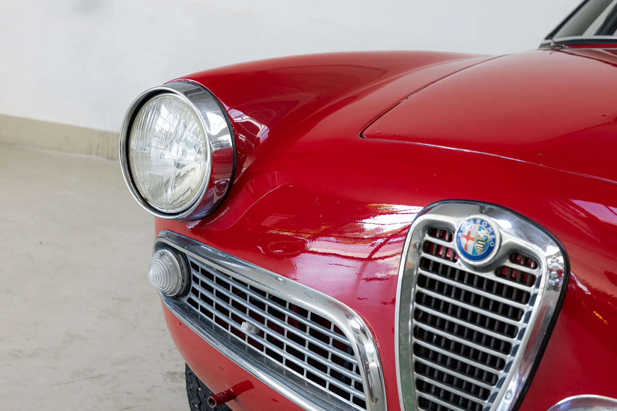 Alfa Romeo Giulia 1600 Sprint 1963 in Rosso Alfa, showcasing the front view and headlight details.