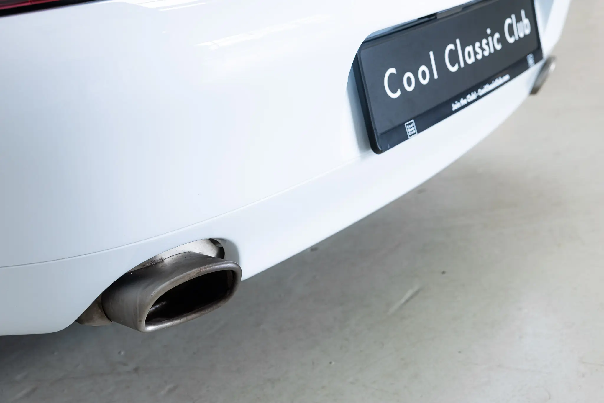 Porsche 993 Targa 1997 in Firnweiss, showcasing the rear view and exhaust details.