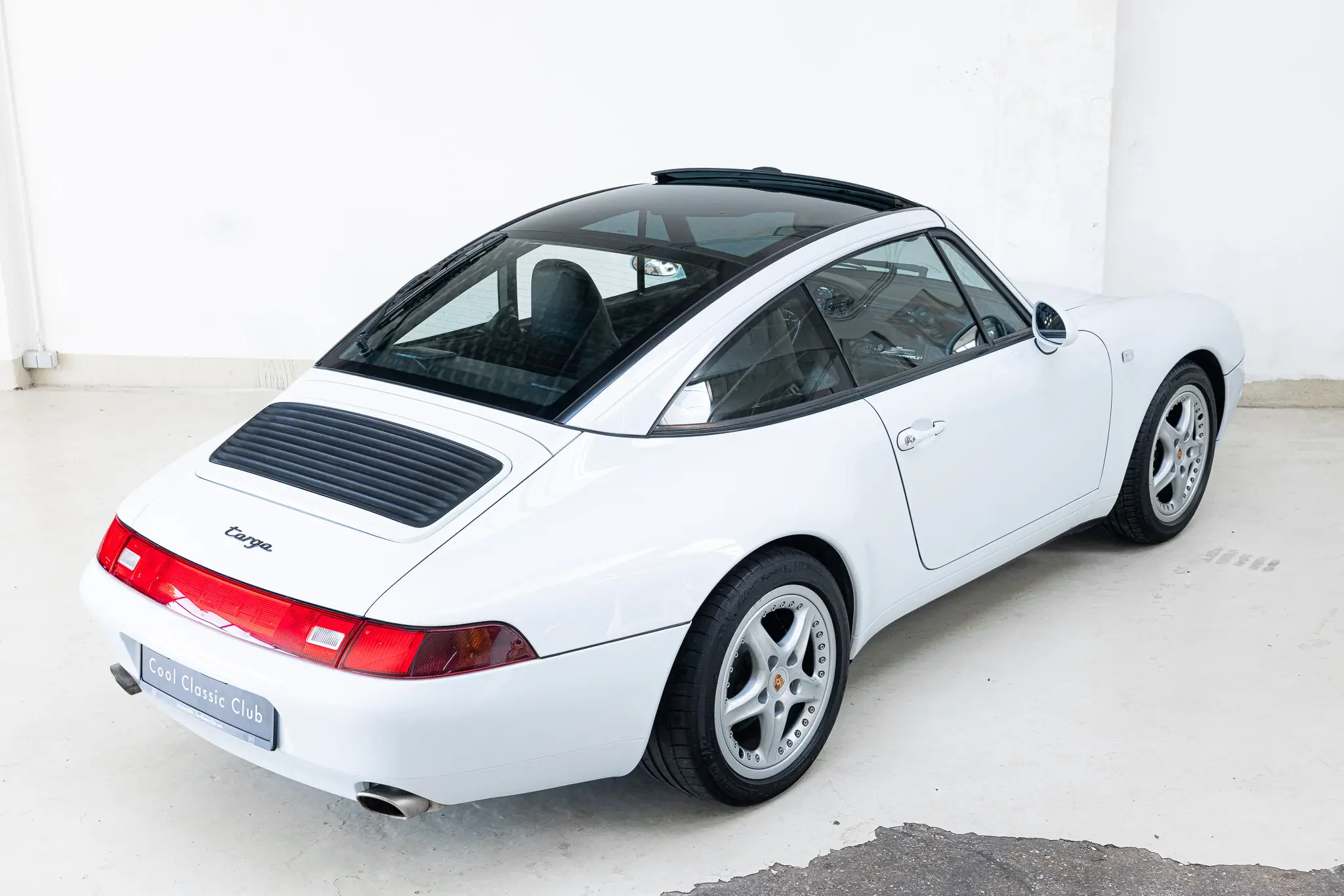 Porsche 993 Targa 1997 in Firnweiss, showcasing a rear view with sleek lines and distinctive design features.