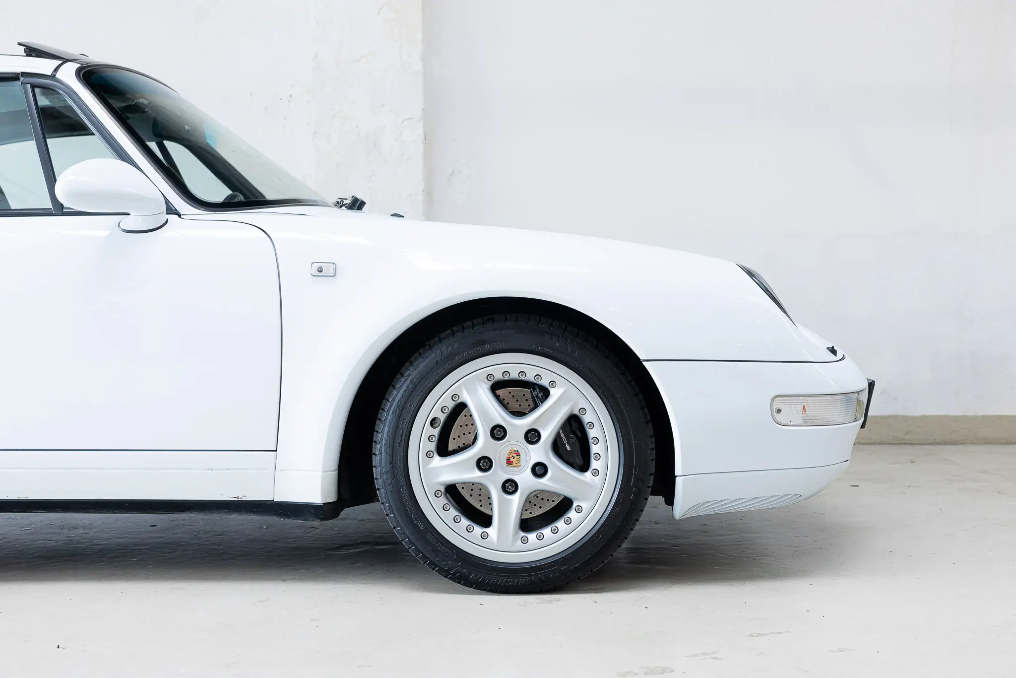 Porsche 993 Targa 1997 in Firnweiss, featuring a side view highlighting the stylish rim and sleek design.