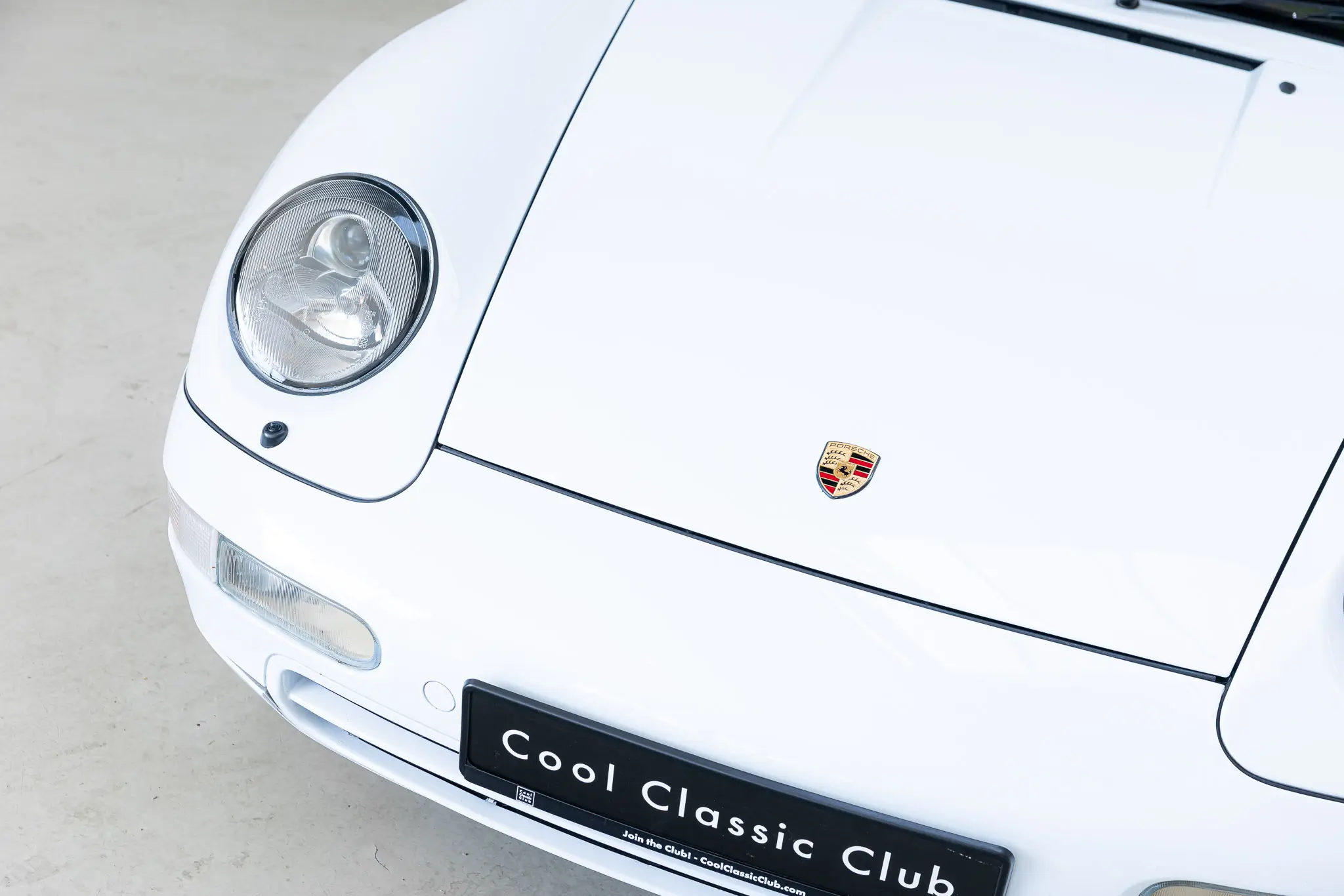 Porsche 993 Targa 1997 Firnweiss, front view with logo and headlight detail.