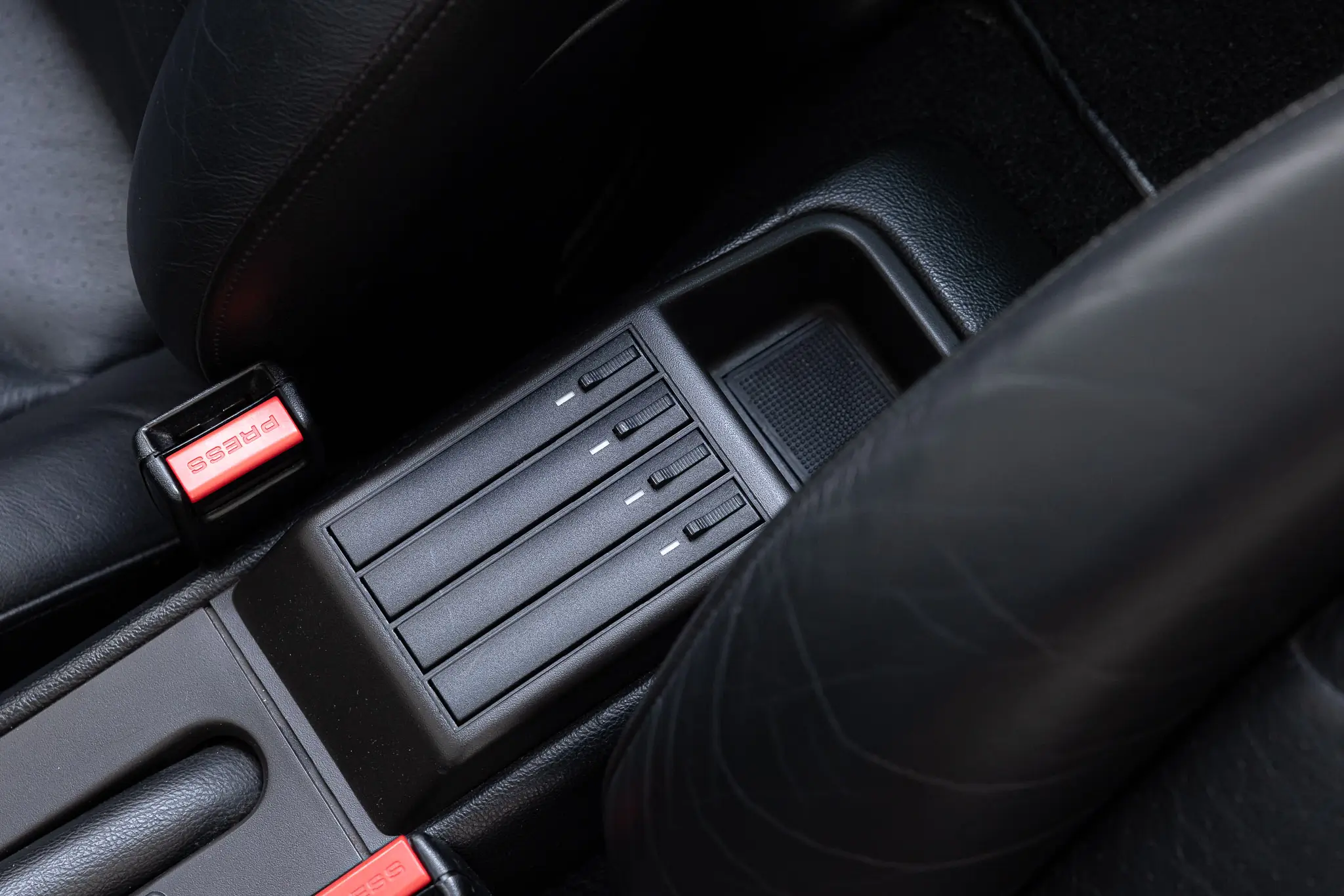 Porsche 993 Targa 1997 in Firnweiss - close-up of the control panel and seatbelt buckle.