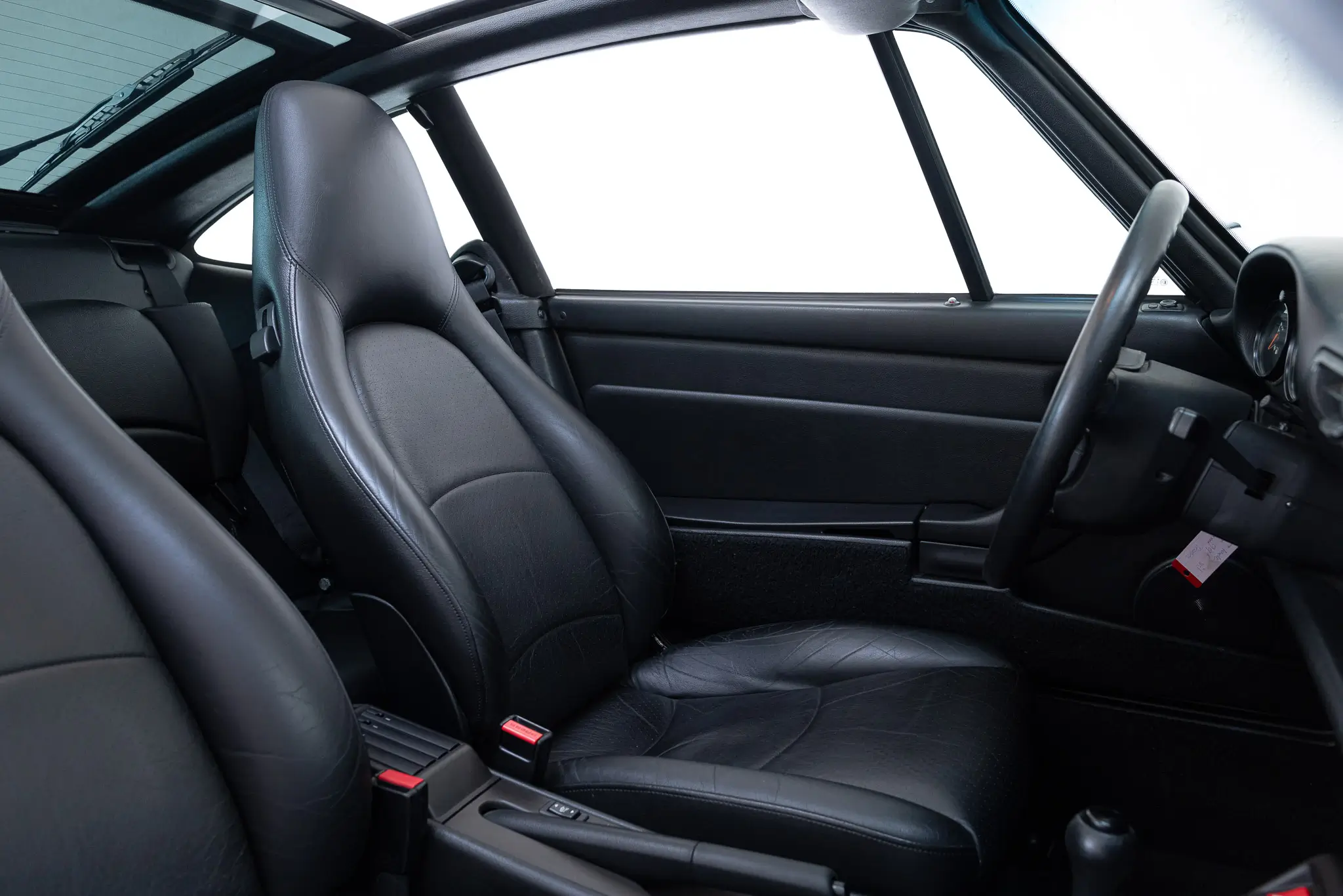 Porsche 993 Targa 1997 Firnweiss interior view showcasing sporty black leather seats.