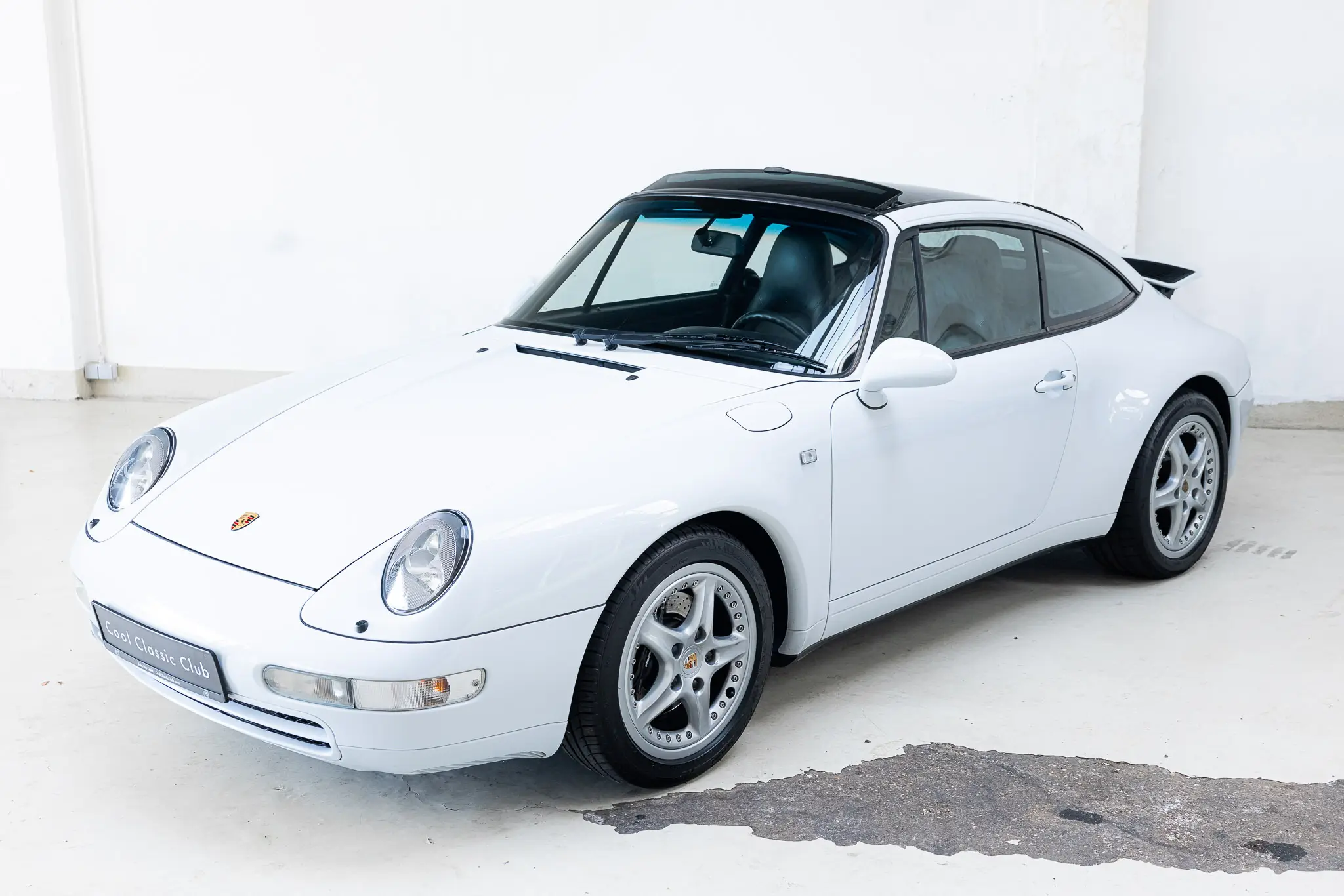 1997 Porsche 993 Targa in Firnweiss, captured from the front-right angle showcasing its sporty design and wheels.