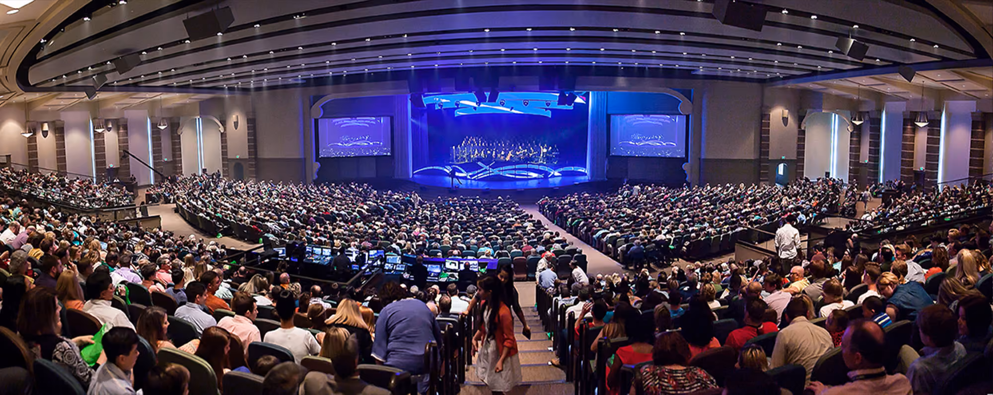 A large sanctuary filled with people watching a church service