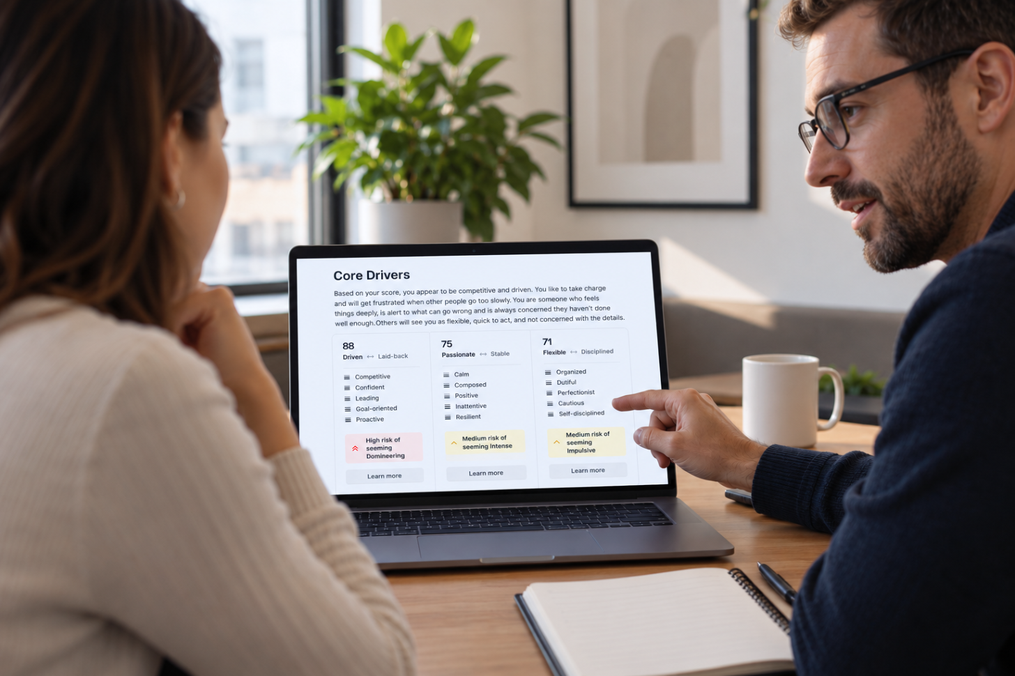 Un manager e un membro del team stanno esaminando insieme, su un portatile, un test di personalità Core Drivers durante un colloquio individuale.