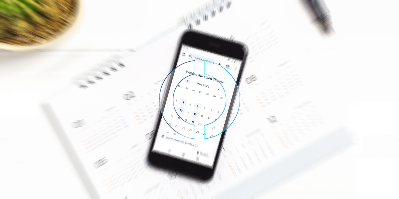 Ein Smartphone liegt auf einem Kalender. Auf dem Smartphone-Display ist der Kalender von EMPORIAS zu sehen.
