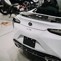 Rear view of a white Lexus LC 500 sports car parked inside Top Wrap's shop
