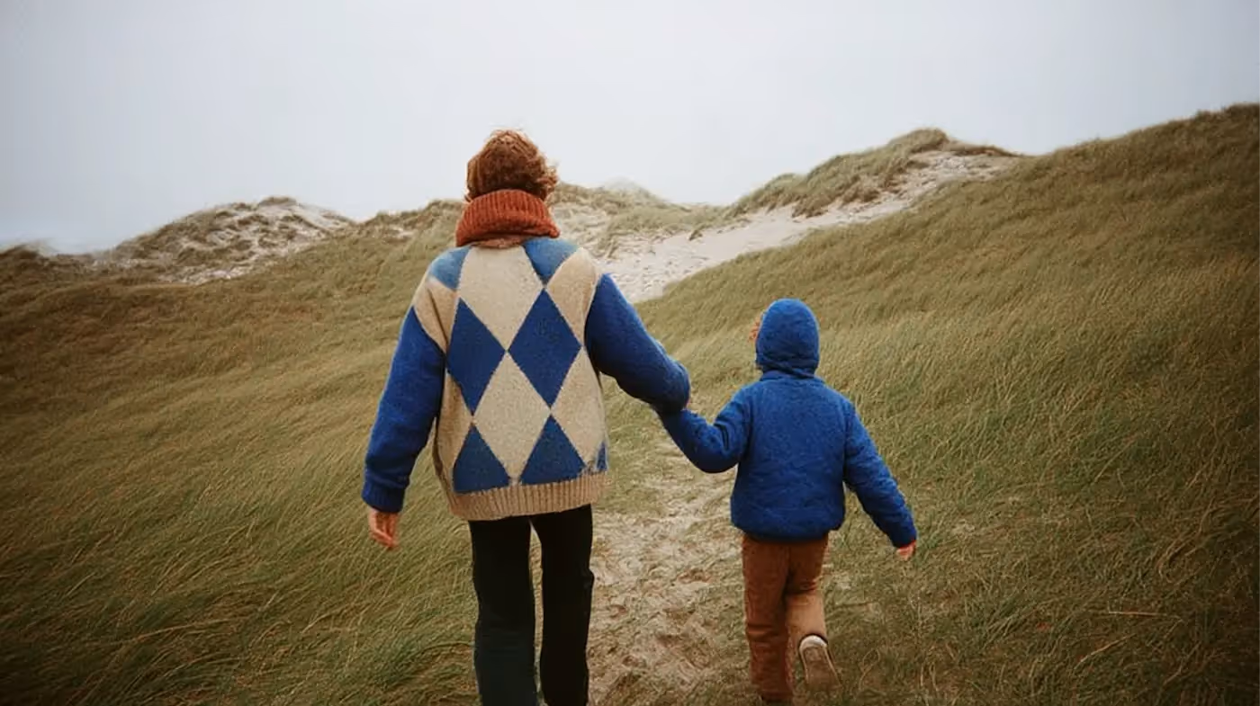 Een ouder en kind wandelen over een pad in de heuvels.