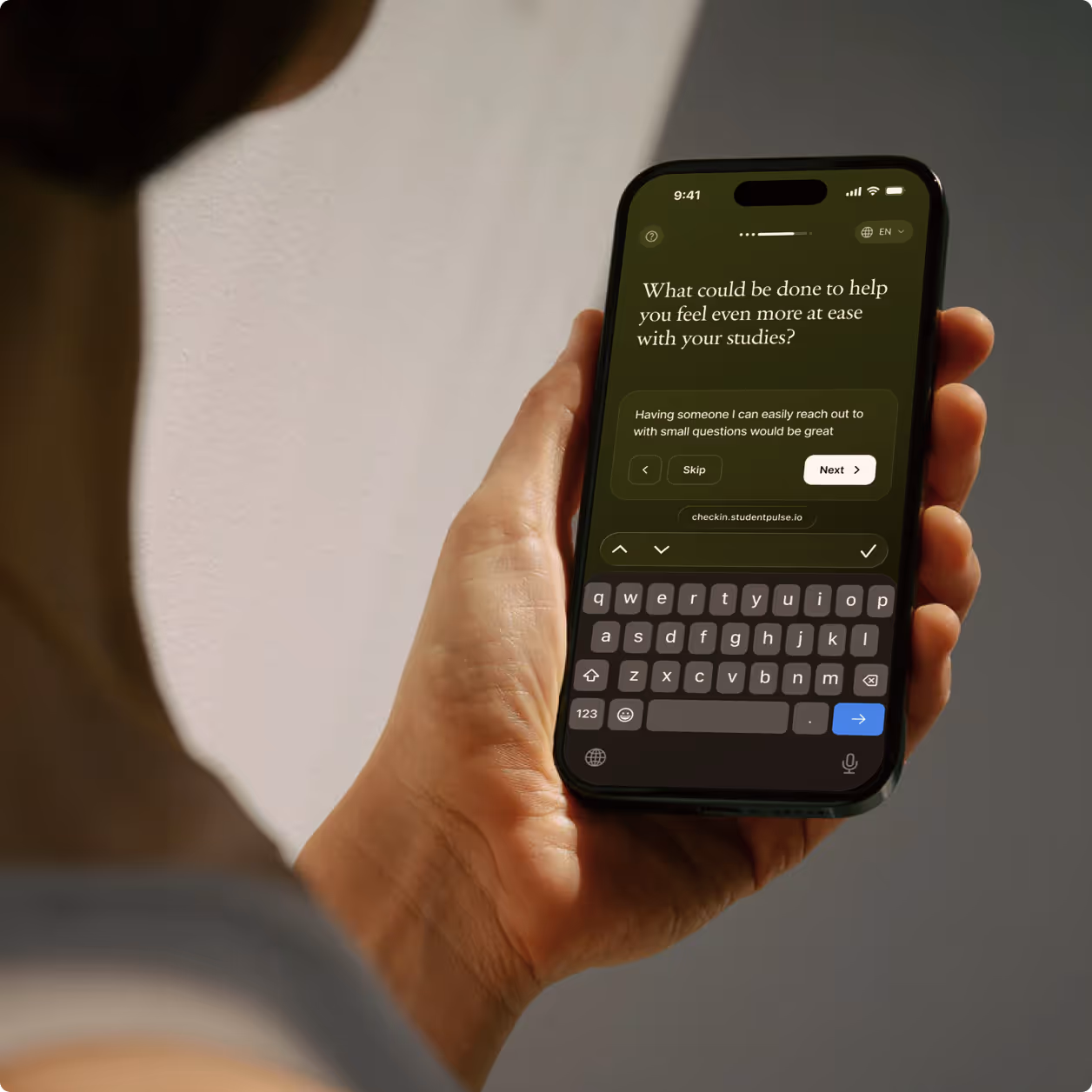 Two smartphones on a wooden surface displaying a survey about exam expectations, one with a scale rating and the other with a text input field and keyboard.