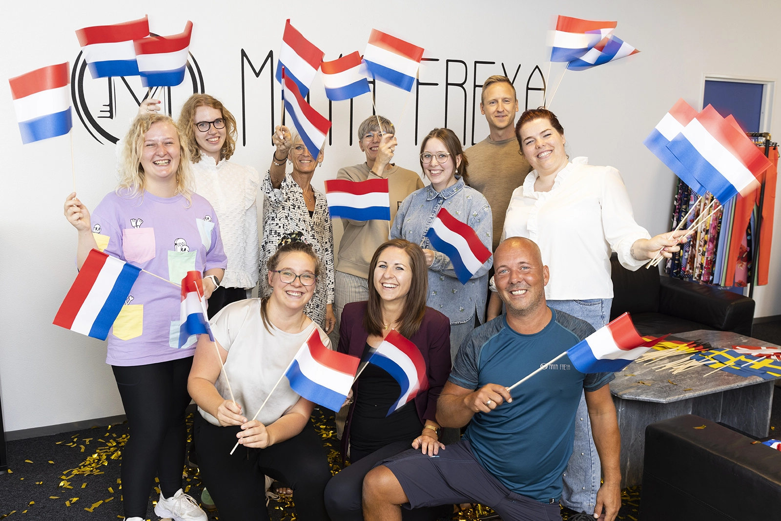 Bilde av Maya Freya-ansatte som står og vifter med nederlandske flagg.